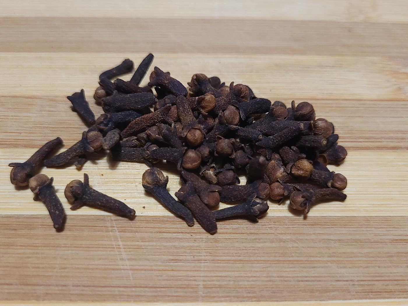 Whole dried cloves on a wooden surface