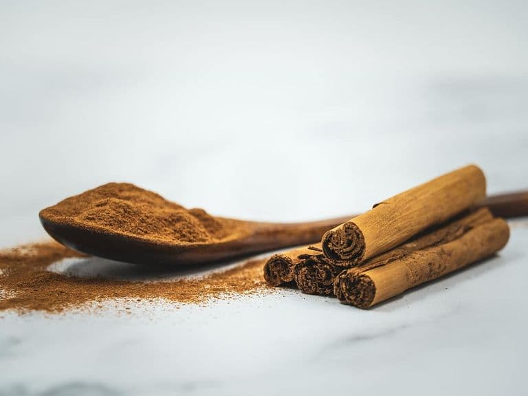 Cinnamon sticks and ground cinnamon on a wooden spoon