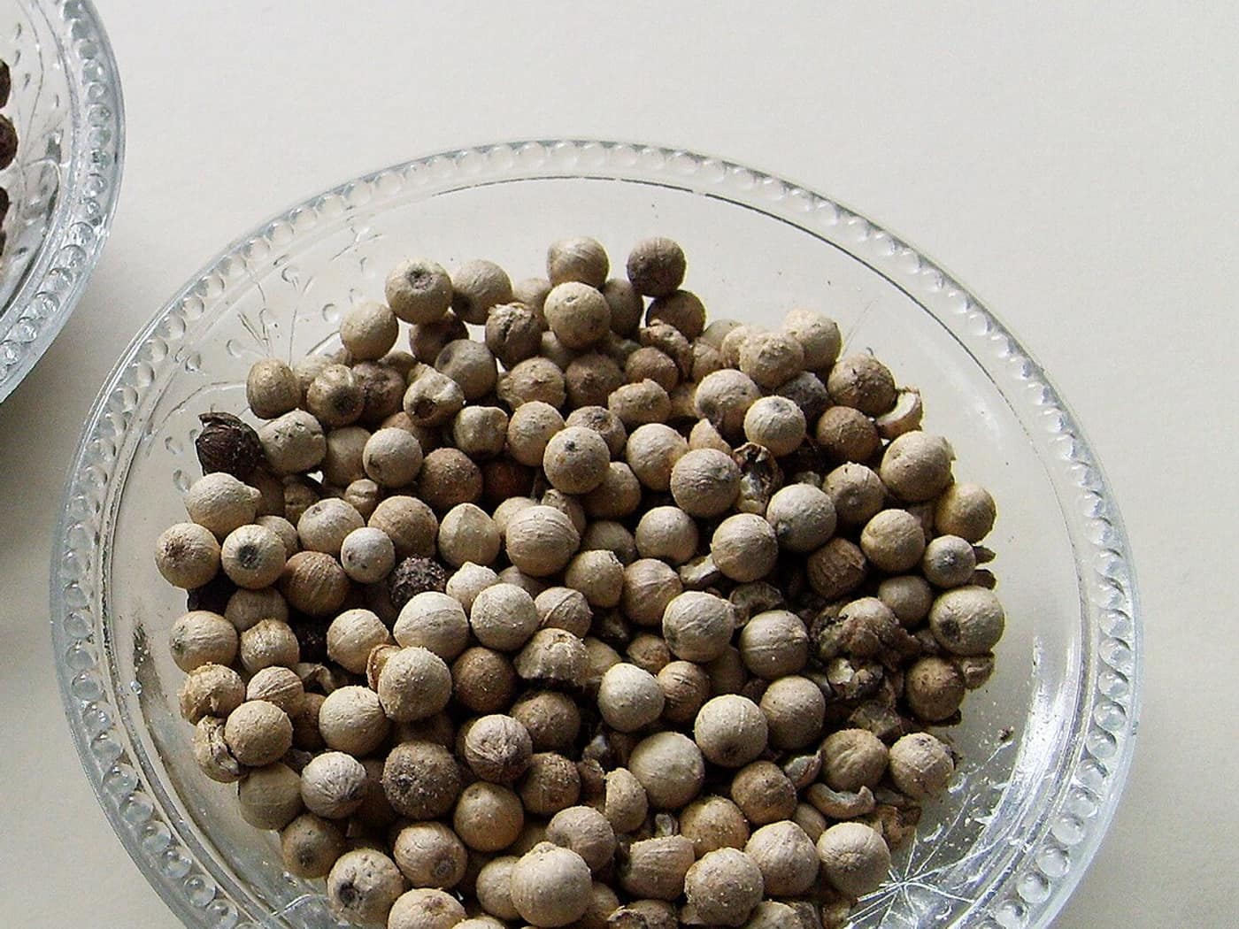 White peppercorns in a glass bowl
